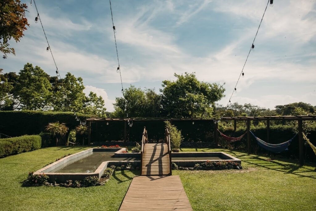 Localizado próximo ao deck de madeira, o espelho d’água contribuipara a composição natural do ambiente, oferecendo um ponto dedestaque discreto e harmonioso.Além de integrar o paisagismo, o espaço pode ser utilizadocomo cenário para fotose lounges aconchegantes,especialmente em celebraçõesmais intimistas.