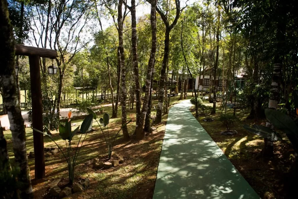 Área encantadora, cercada por vegetação nativa e umpaisagismo cuidadosamente planejado, com flores,arbustos eumvisualharmonioso.Oespaço conta com:•Mini gazebo,perfeitopara fotos emomentos especiais;• Parquinho infantil, garantindo diversão para ospequenos;• Uma acolhedora fogueira entre as árvores, ideal paraaquecer os convidados e criar um clima intimista —mesmonosdiasmais frios.