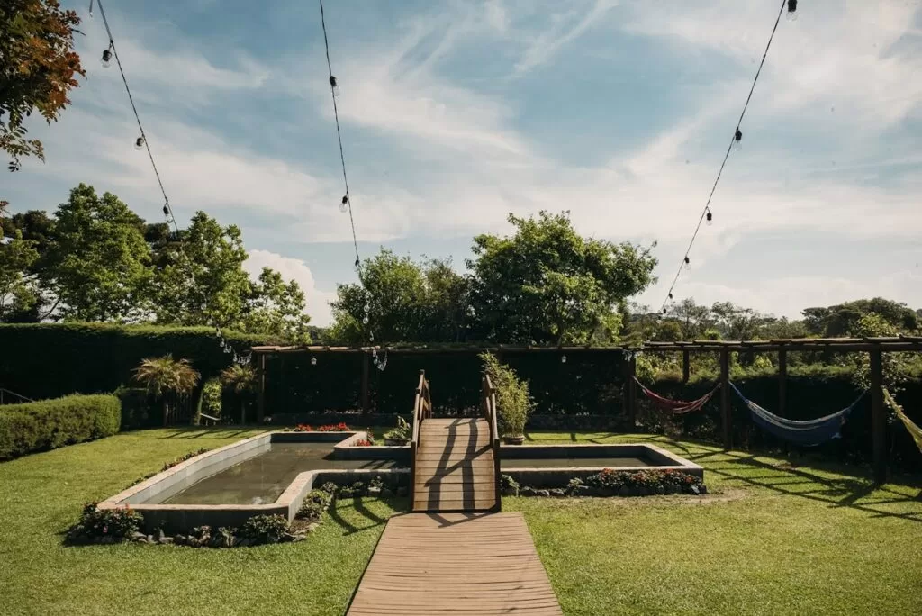 Localizado próximo ao deck de madeira, o espelho d’água contribuipara a composição natural do ambiente, oferecendo um ponto dedestaque discreto e harmonioso.Além de integrar o paisagismo, o espaço pode ser utilizadocomo cenário para fotose lounges aconchegantes,especialmente em celebraçõesmais intimistas.